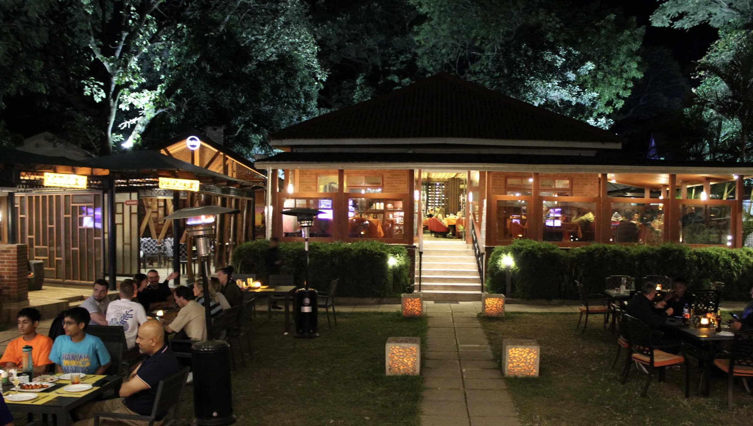 Guests dining on the lawn at night in front of Amber's lit pavilion